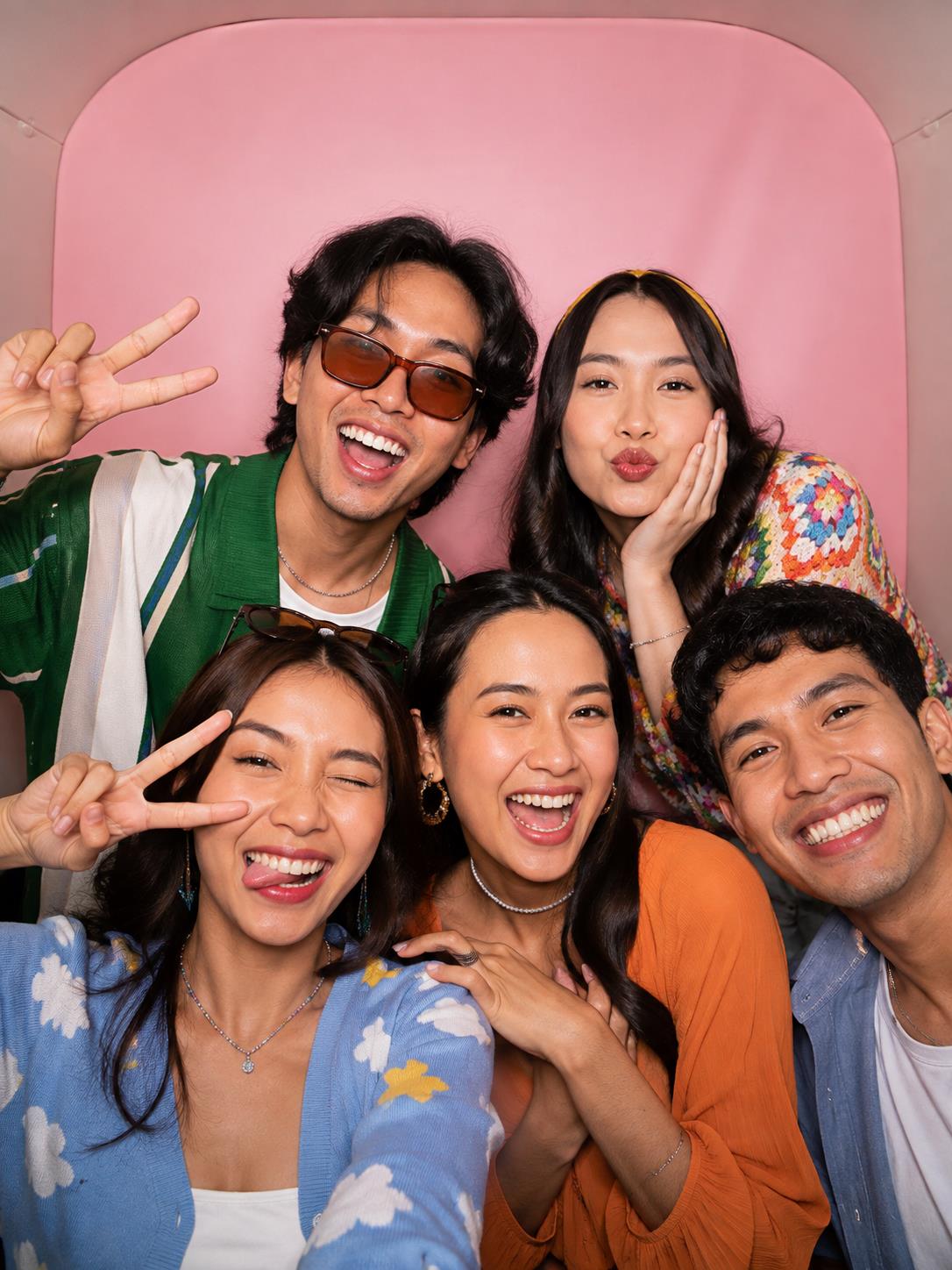 Ilustrasi teman-teman berpose ceria dengan latar pink di photobooth